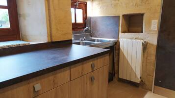 Una cocina con encimera de madera, un lavabo y una ventana.