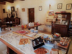 A breakfast buffet with various food items and a marble countertop. - Hotel Manoir de Mathan (Crepon)