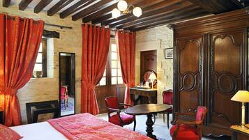 Una stanza con un letto, una scrivania in legno, due sedie e un tavolo.