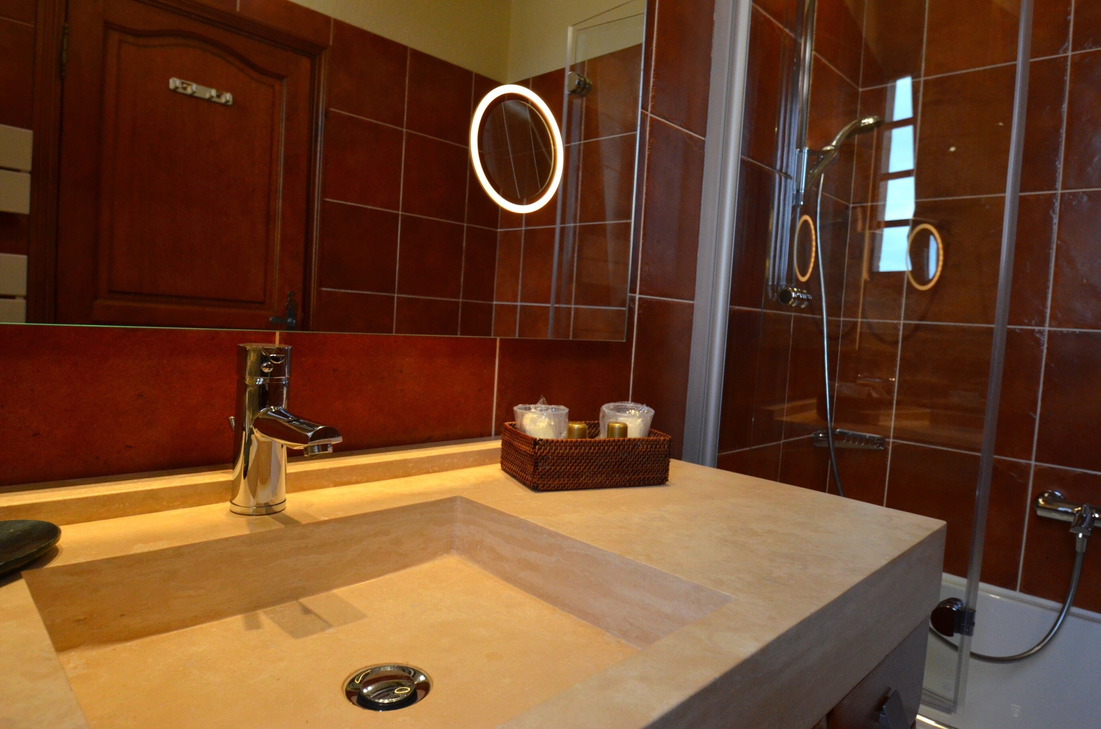 Een badkamer met een groot wastafel, een spiegel en een douche.