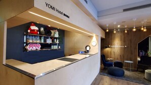 A reception area with a counter, shelves with various items, a clock, and a 'Welcome Home' sign.