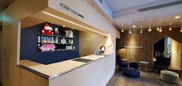 A reception area with a counter, shelves with various items, a clock, and a 'Welcome Home' sign.