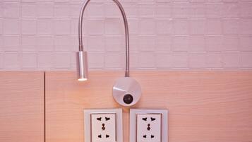 Un baño moderno con lavamanos fijado a la pared, un grifo y dos tomas de corriente.