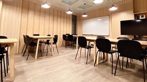 A conference room with wooden panel walls, a whiteboard, and a flat-screen TV.