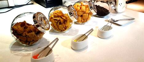 Una mesa de buffet con diversos alimentos y utensilios para servir.
