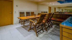 A dining area with a wooden table and chairs, a bench, and a large mirror on the wall. - Hotel Kolumbs (Liepaja)