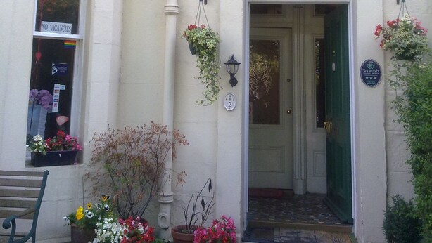 A building with a white facade, a visible number '2' on the door, and hanging flower baskets. - Mackenzie Guest House (Edinburgh)