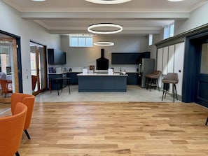 Cozinha moderna com ilha central, armários escuros e uma janela grande.