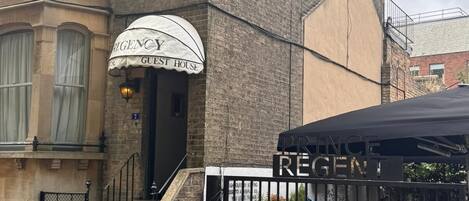 A building with a sign for 'Regency Guest House' and a black awning.
