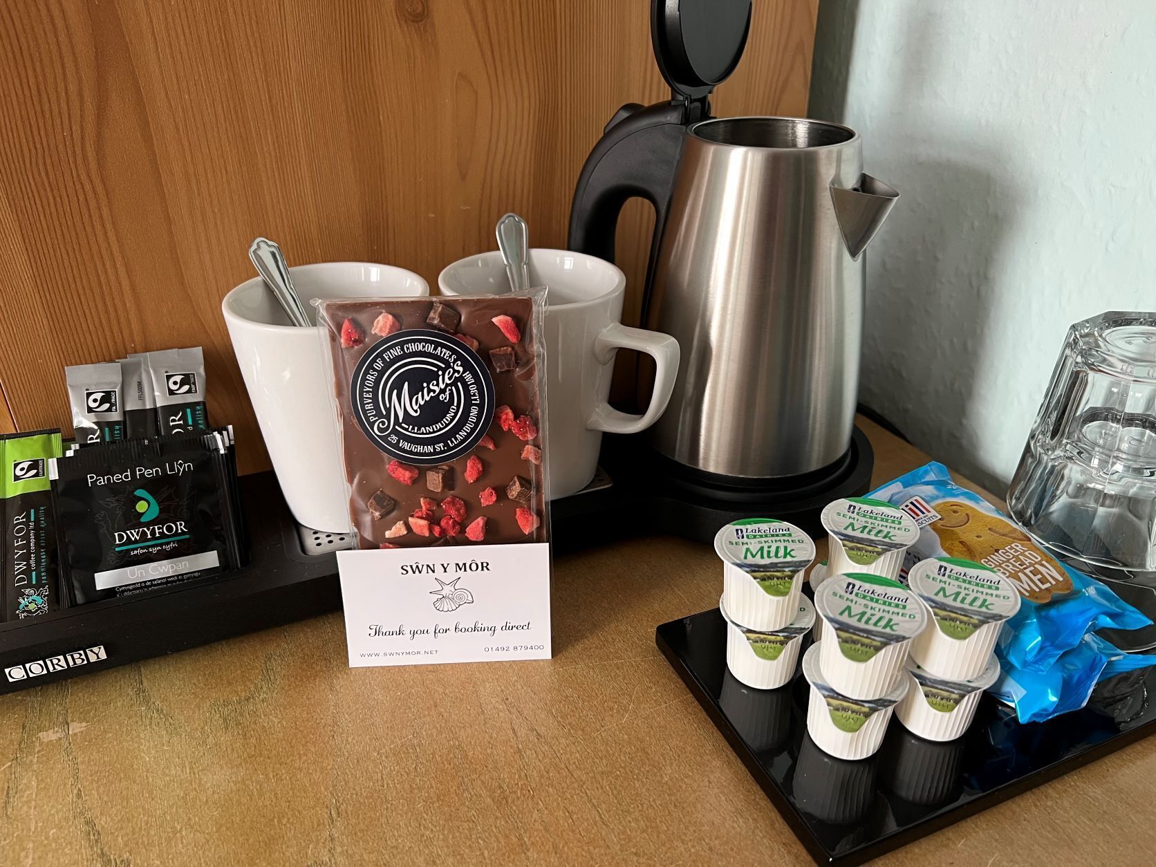 Esmorzar amb una cafetera, una barra de xocolata i envasos de llet.