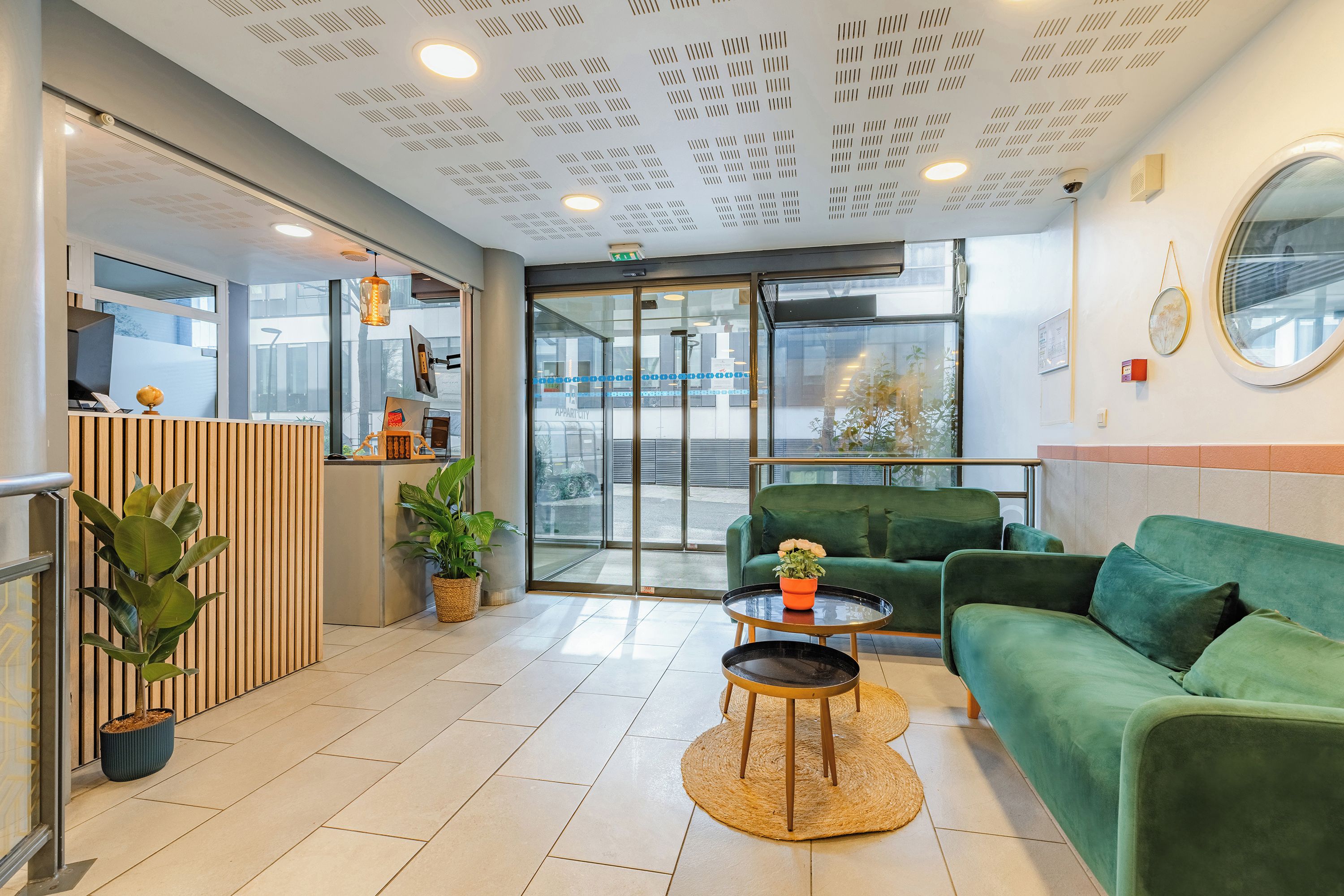 A reception area with a green sofa, a round coffee table, and a reception desk.