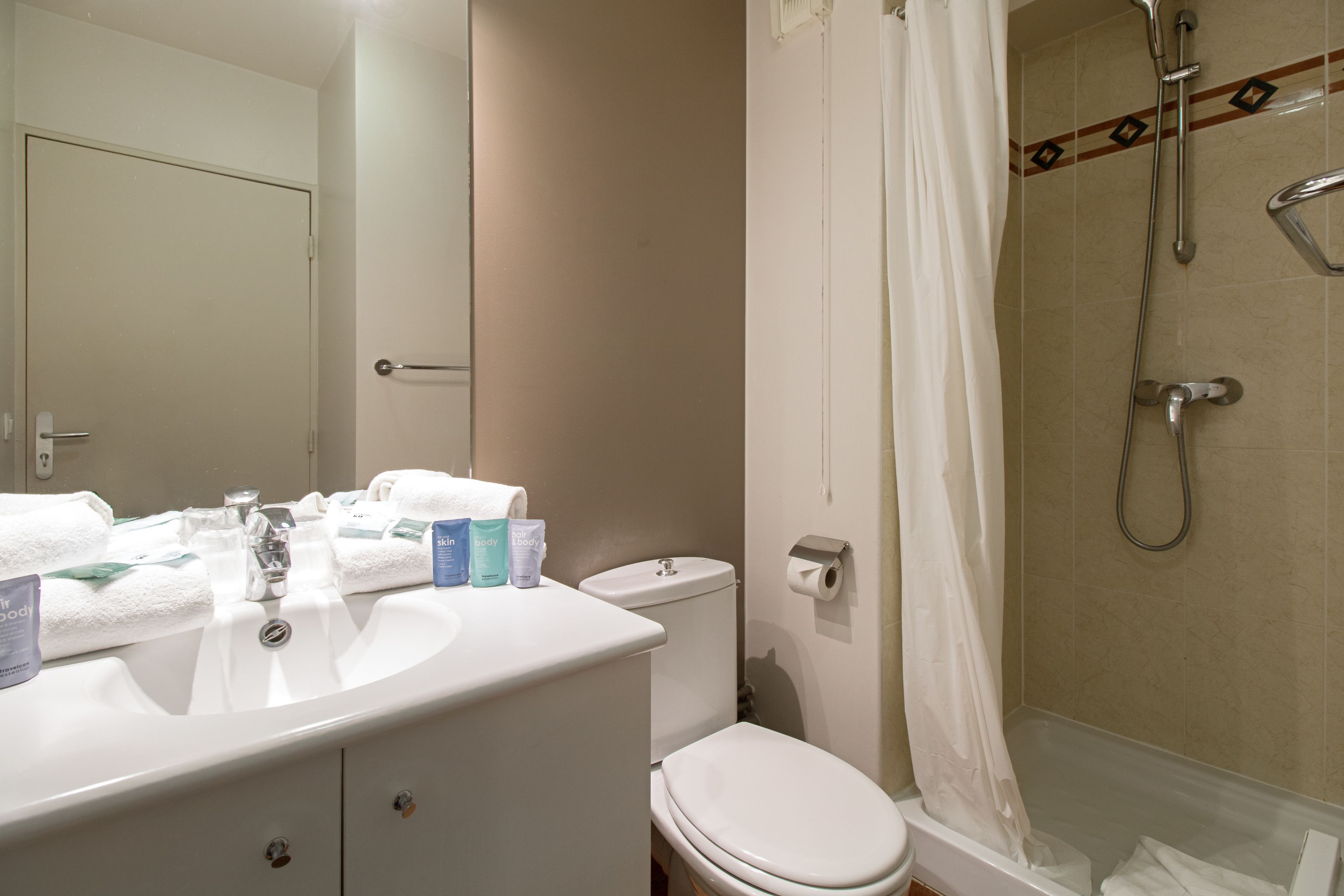Un baño con lavamanos, inodoro y ducha.