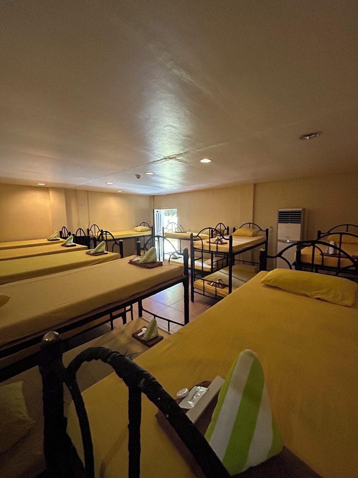 Een hotelkamer met stapelbedden, een groot raam en een airconditioning.