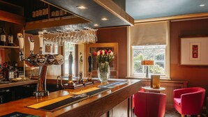 A bar area with a wooden counter, multiple taps, and a vase of flowers. - The Old Orleton Inn (Telford)