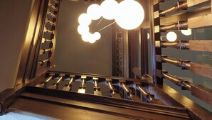 A wooden staircase with a modern light fixture. - The Old Orleton Inn (Telford)