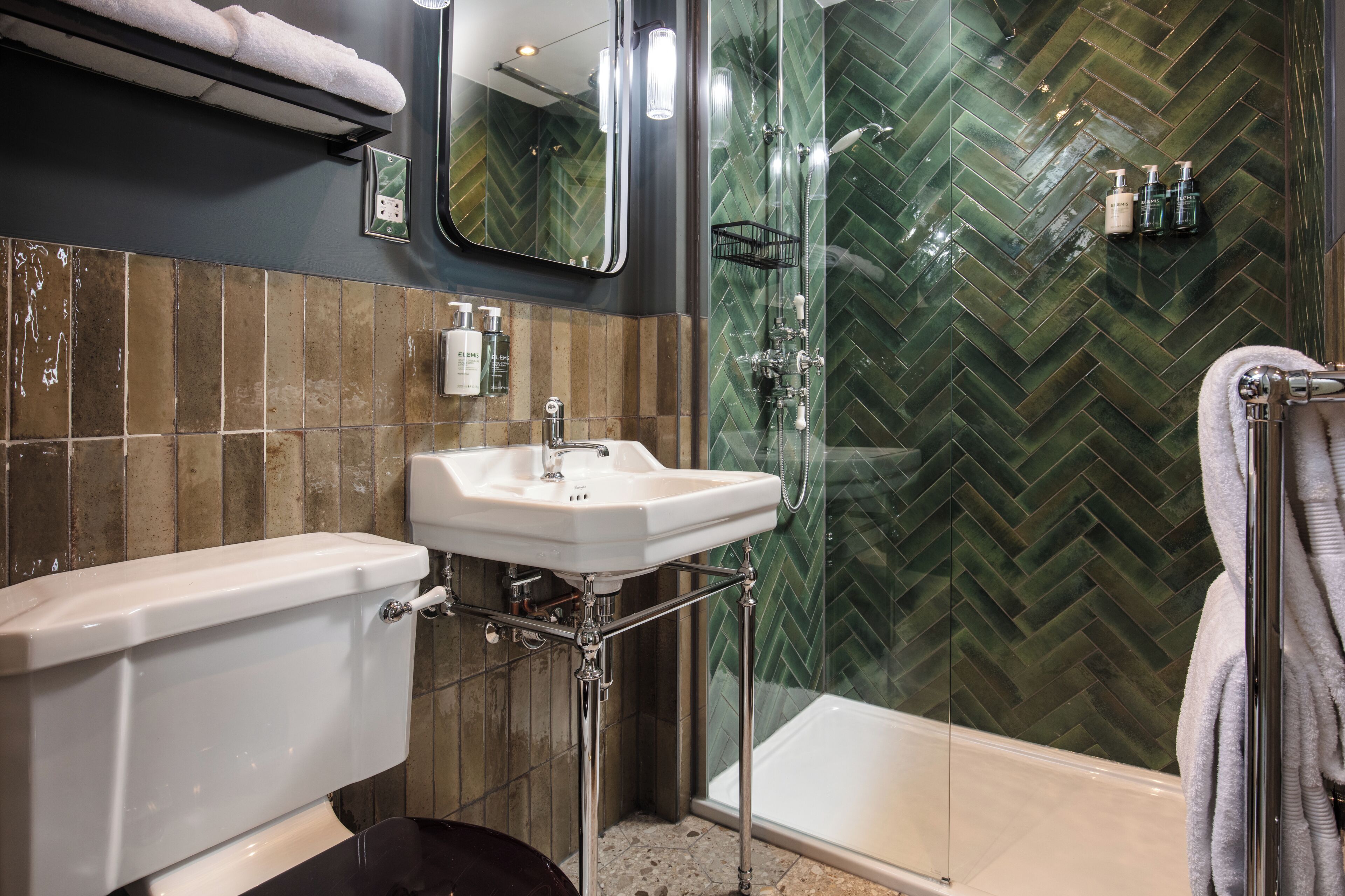 Un baño con inodoro, lavamanos y zona de ducha.