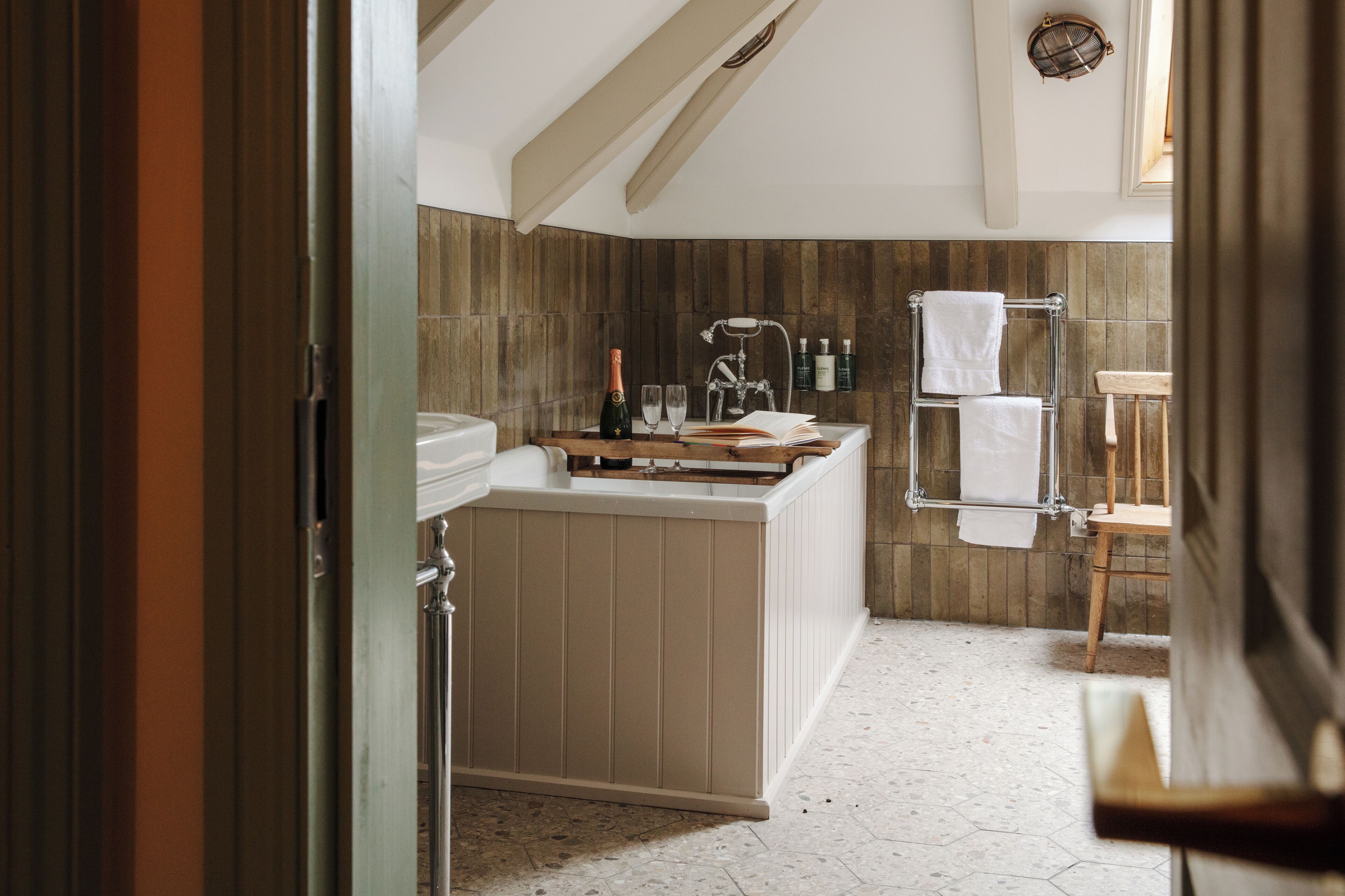Une salle de bain moderne avec un meuble-lavabo en bois, un porte-serviettes et un espace douche.