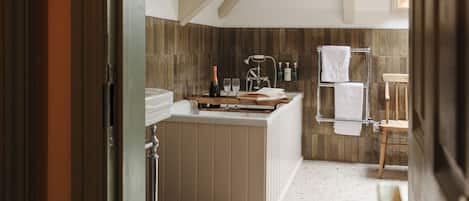 Un baño moderno con tocador de madera, un perchero y una zona de ducha.
