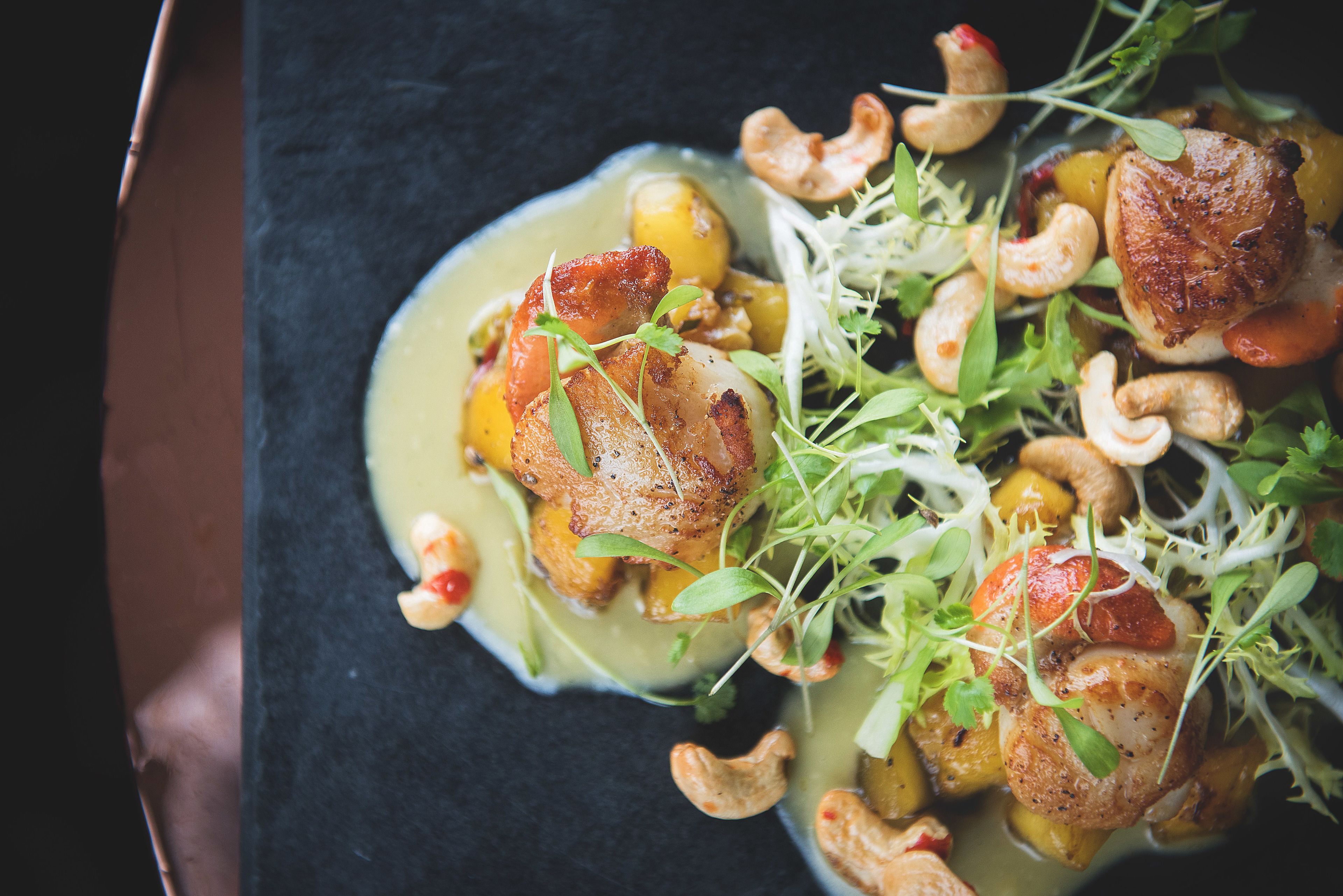 Een bord met diverse ingrediënten, waaronder cashewnoten en groenten.