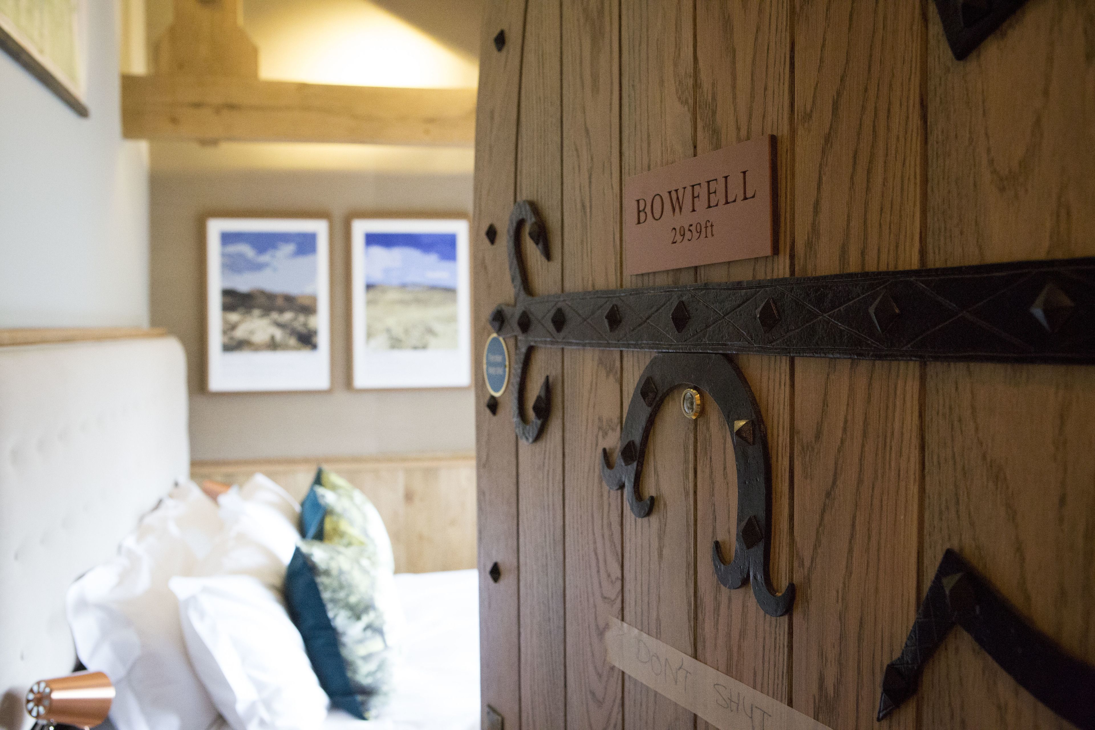 En trädörr med en skylt som visar texten: ”BOWFELL 2959 fot”.