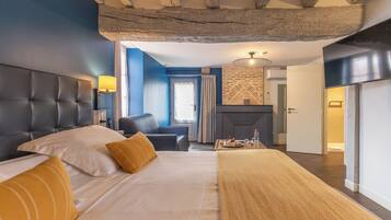 Un dormitorio con una cama grande, una silla, una chimenea y vistas al exterior.
