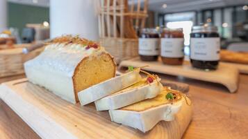 Una hogaza de pan con corteza blanca y una rebanada cortada, sobre una tabla de madera.