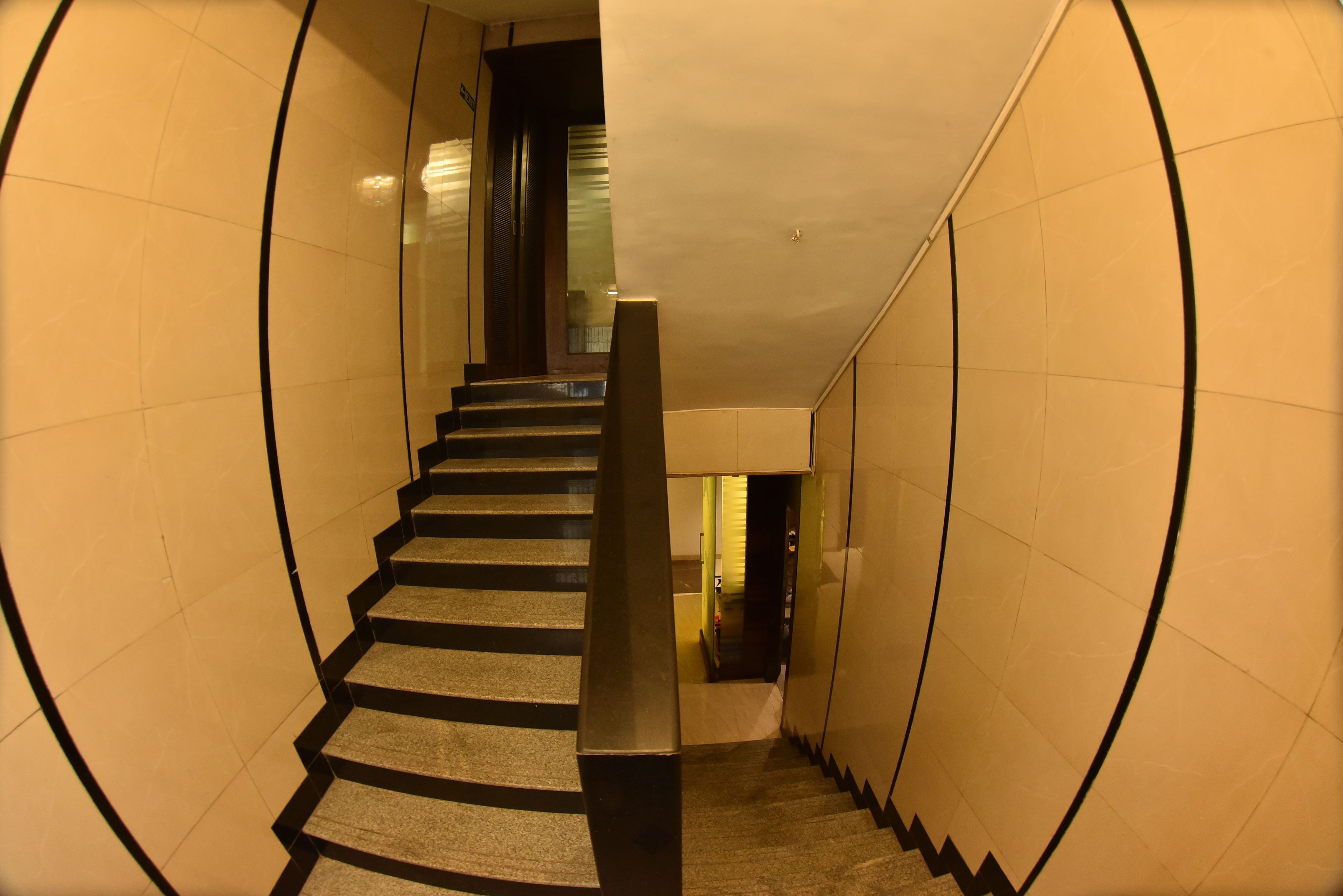 A staircase with a handrail, leading to a landing with a door.