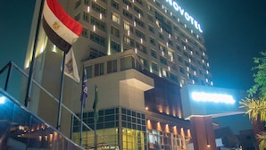 A hotel with a modern design, featuring a prominent entrance with glass doors and a well-lit facade.