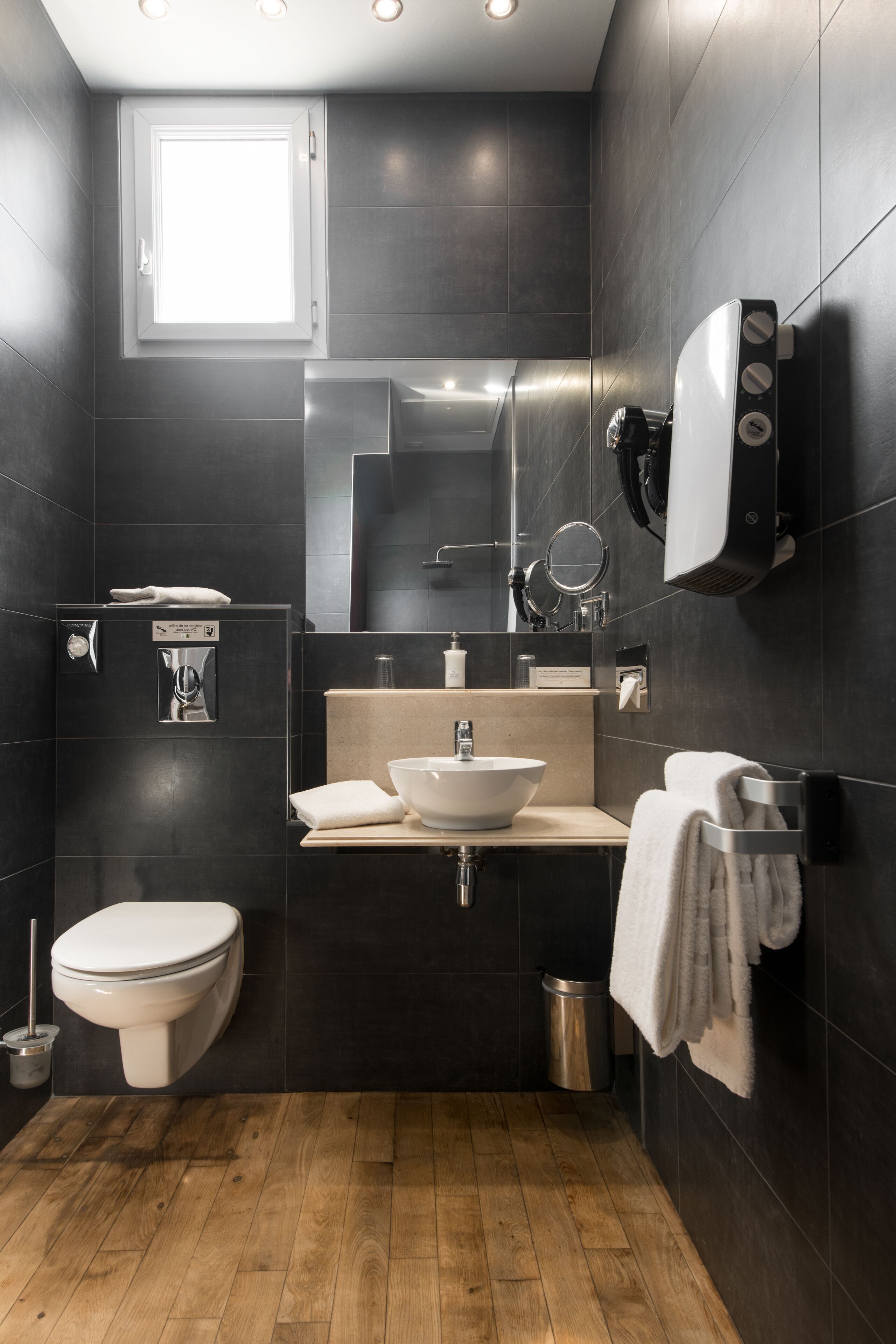 A modern bathroom with a toilet, sink, and mirror.