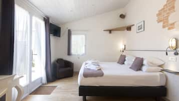 Een slaapkamer met een bed, een stoel, een televisie en een raam met gordijnen.