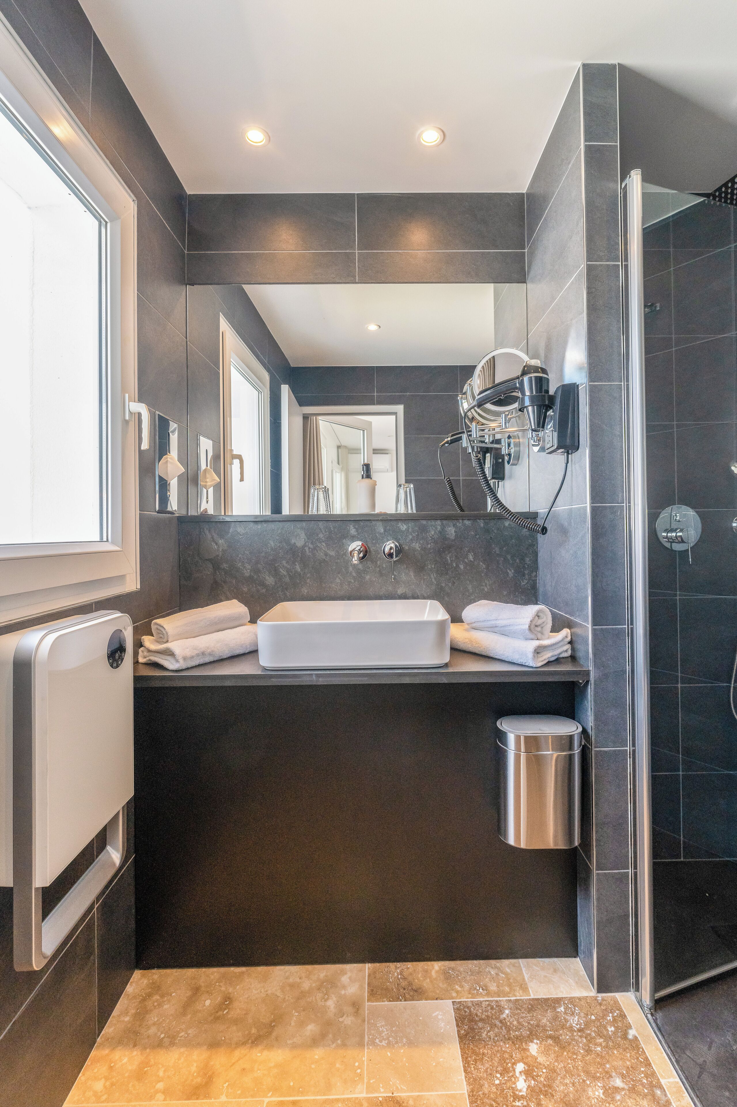 Un baño moderno con una bañera grande, un espejo, un perchero para toallas y una zona de ducha.