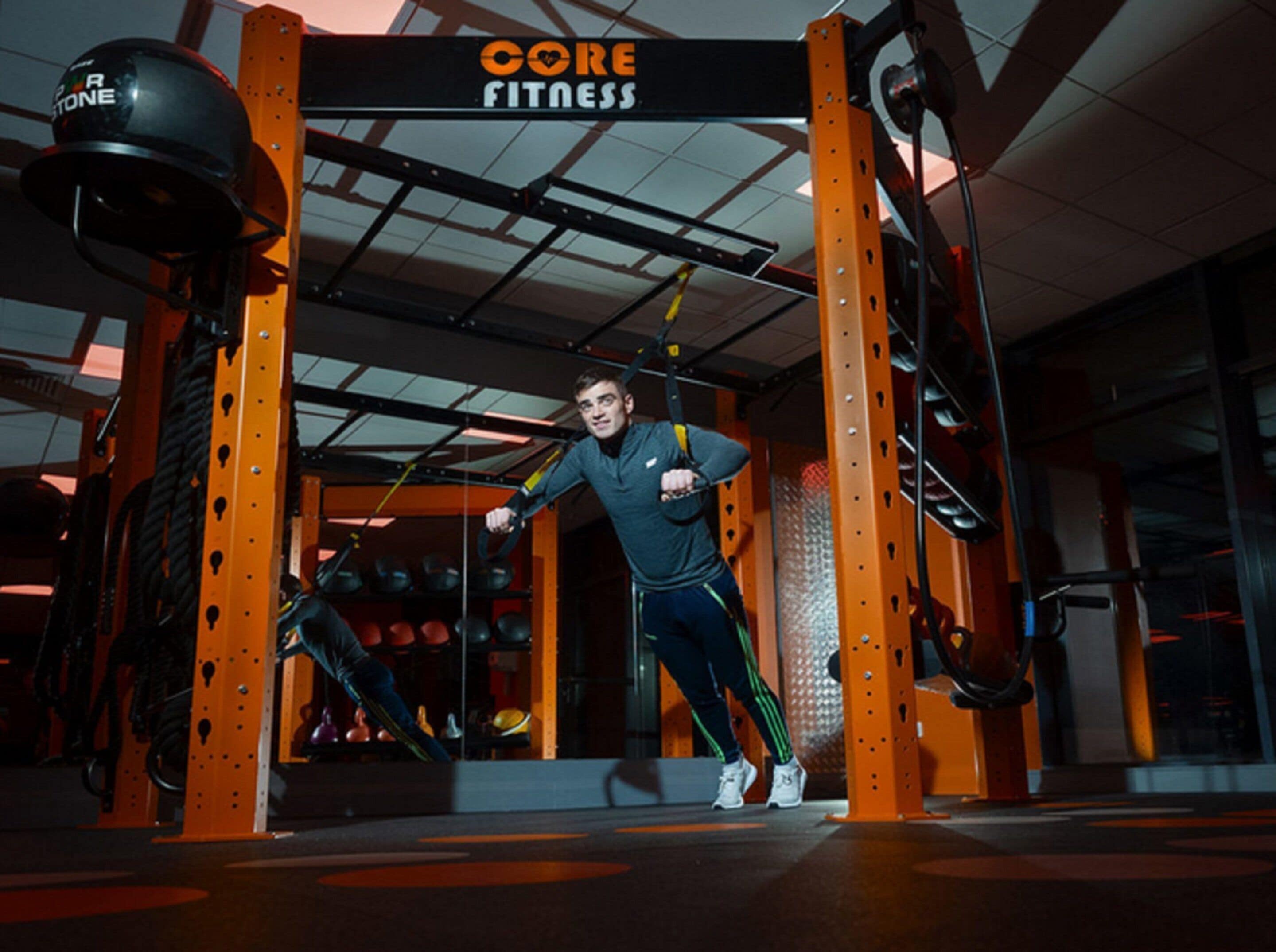 Un gimnasio con barra de dominadas y un cartel que dice 'CORE FITNESS'.