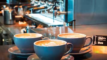 Three cups of coffee with latte art on a bar counter in a cafe.