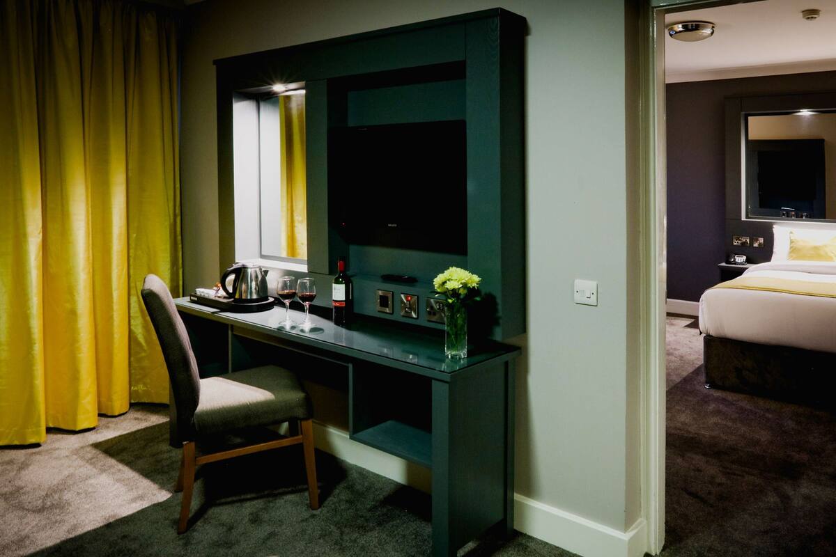 Une chambre d’hôtel équipée d’un bureau, d’une chaise et d’un lit.