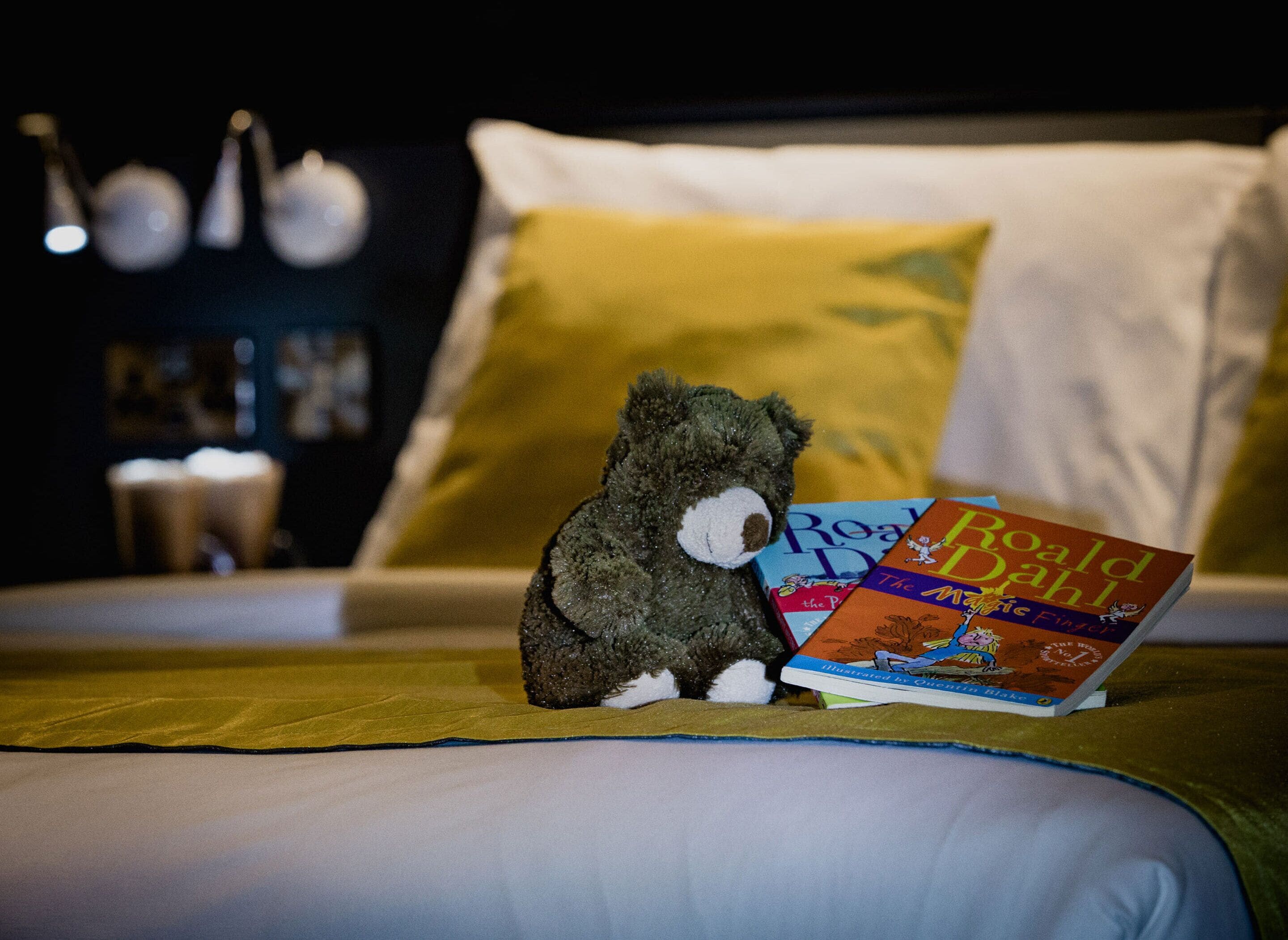 A bed with a plush toy and a book titled 'The Miracle of the Little Duck'.