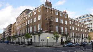 A multi-story residential building with a brick facade, multiple windows, and a gated entrance. - Amber Residence Hotel (London)