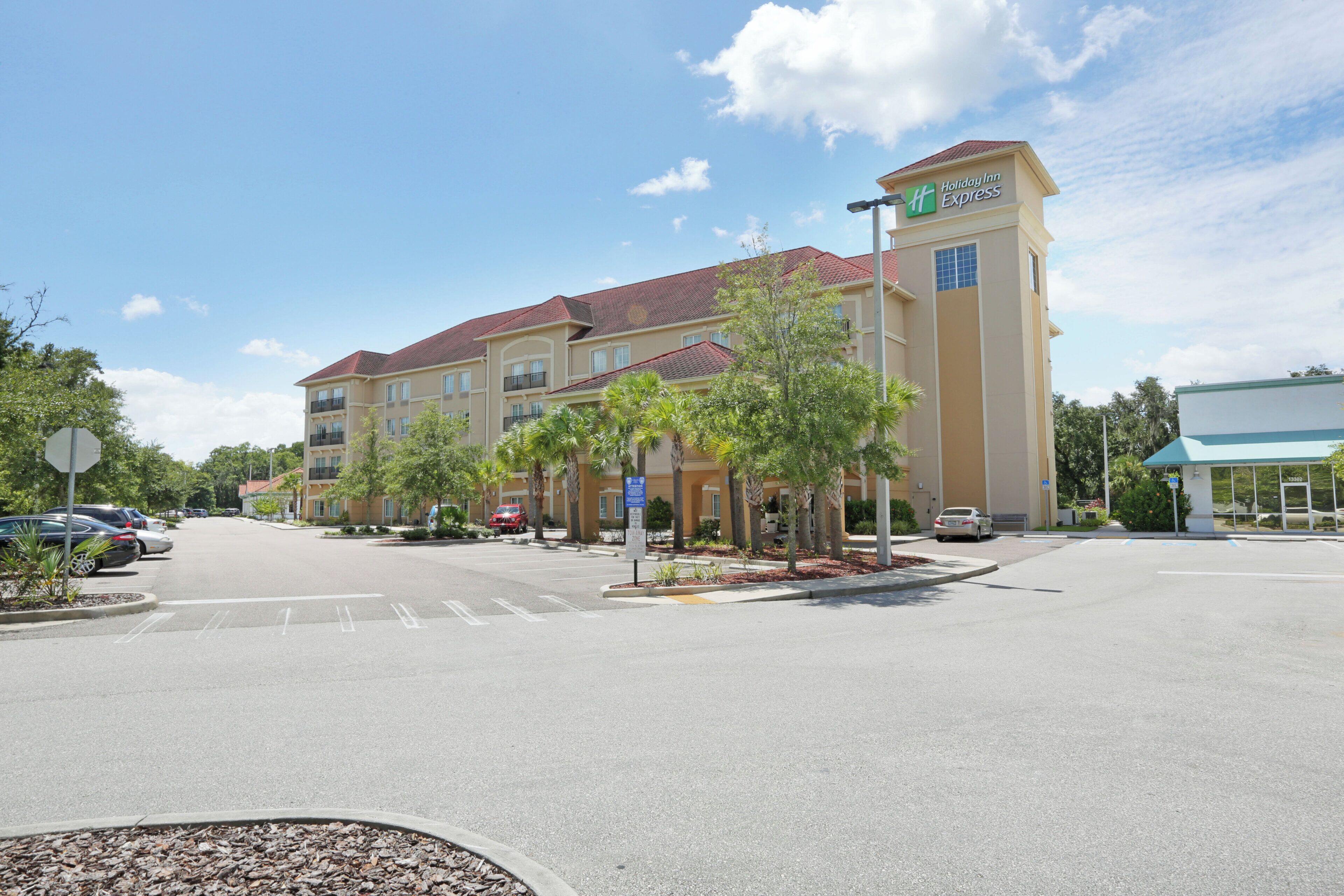 A Holiday Inn Express hotel with a red roof, multiple balconies, and a parking lot.