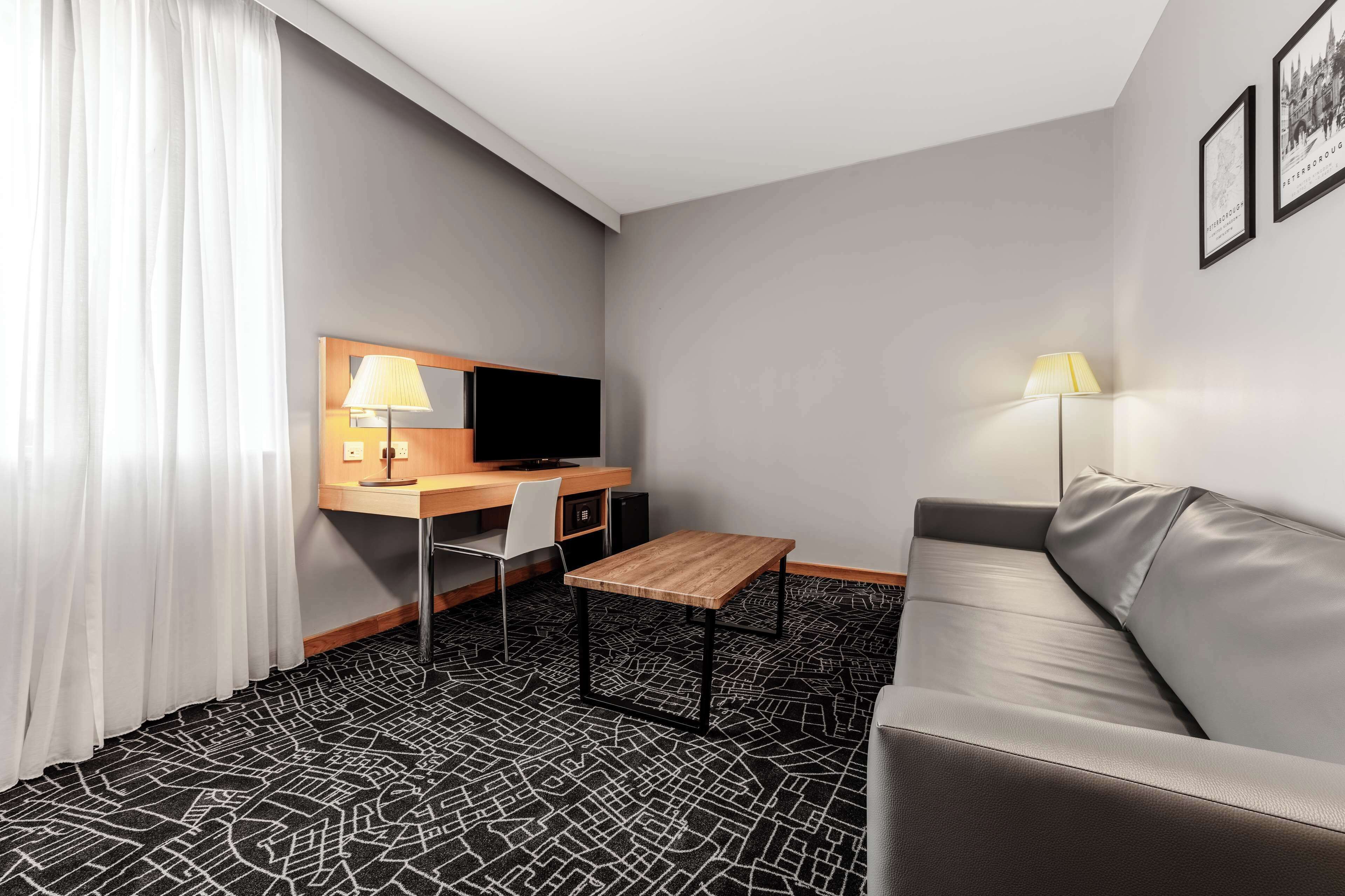 Ein Hotelzimmer mit Schreibtisch, Stuhl und Sofa.