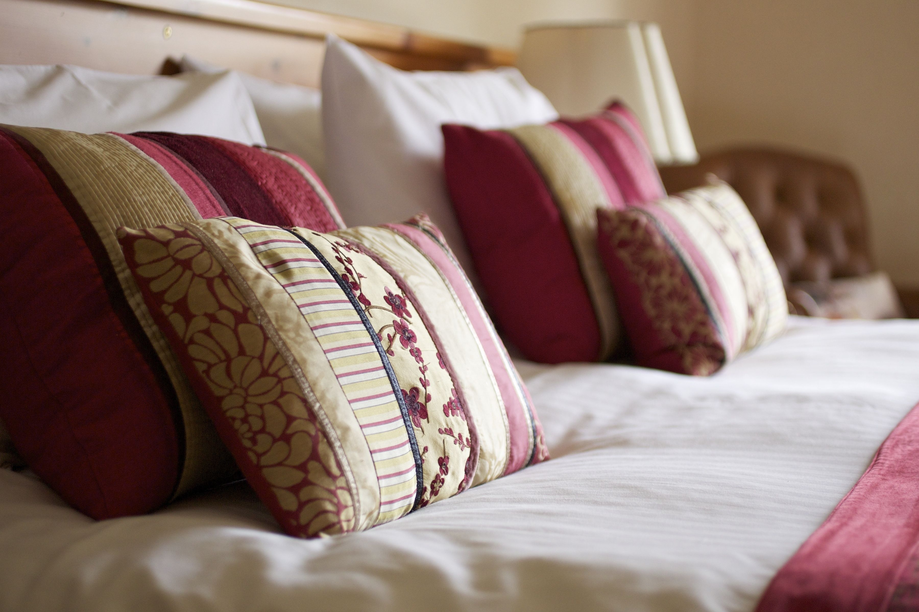 A neatly made bed with multiple pillows and a headboard.