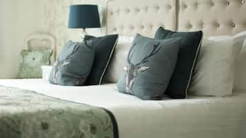 A neatly made bed with a patterned bedspread, a tufted headboard, and decorative pillows.