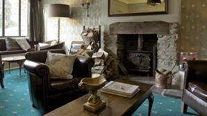 A cozy living room with a stone fireplace, leather furniture, and a large mirror. - Exmoor White Horse Inn (Minehead)