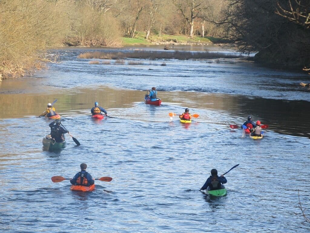 A group of kayakers on a river.