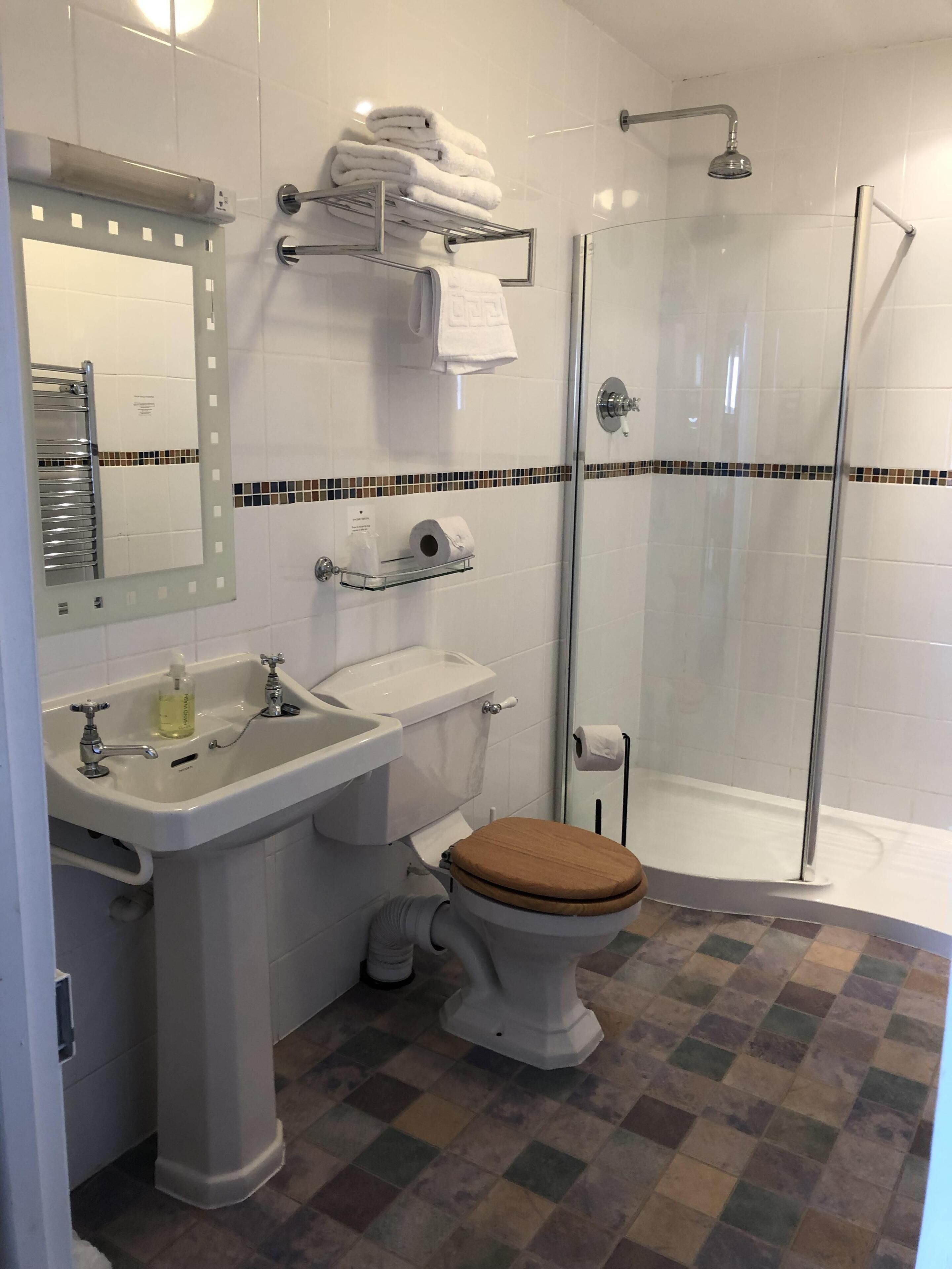 A bathroom with a sink, toilet, and shower.