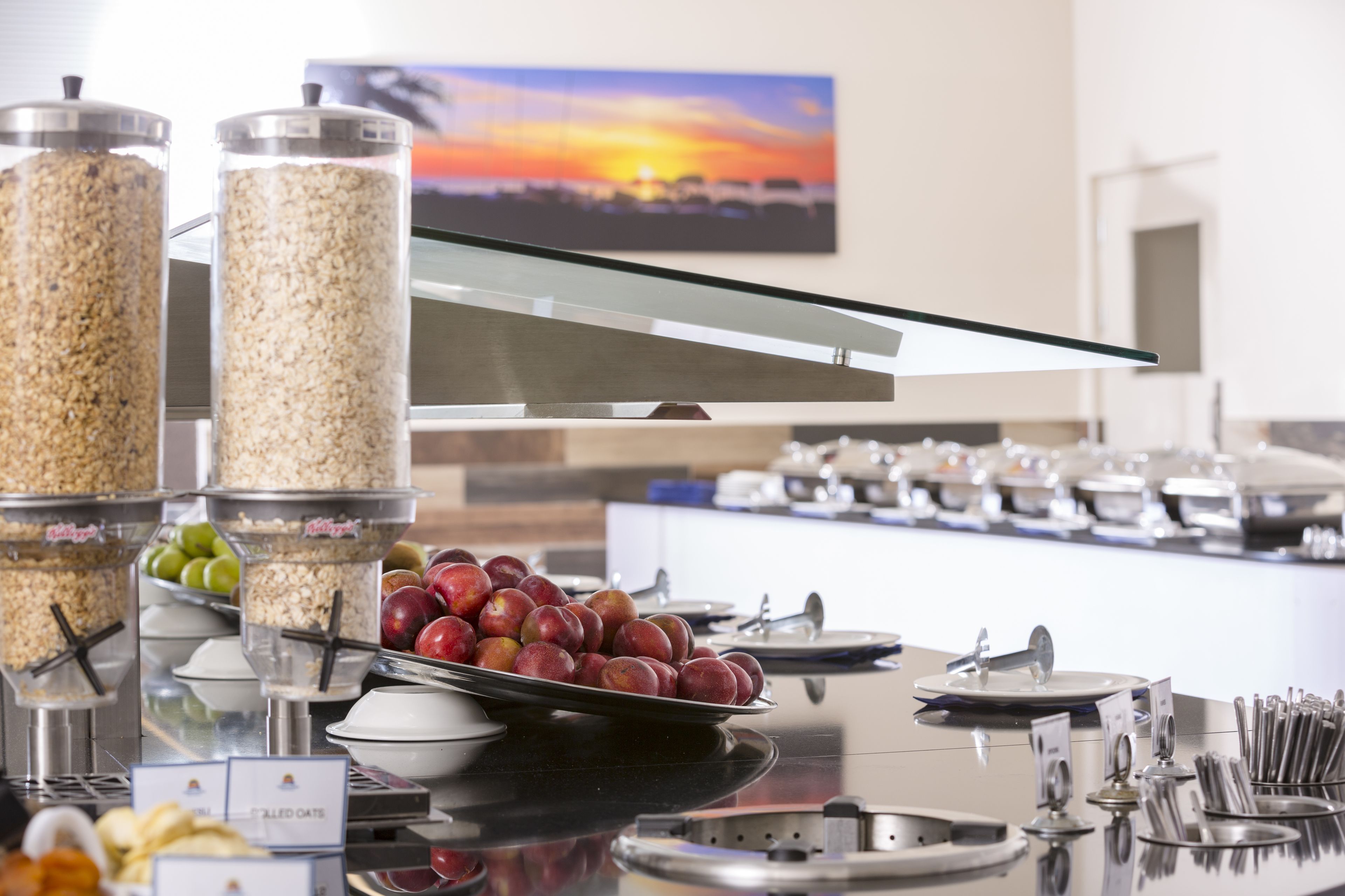 A buffet setup with various food items and utensils.