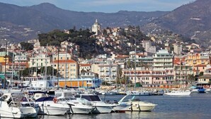 Une ville côtière aux bâtiments aux couleurs vives, avec un port de plaisance rempli de bateaux.