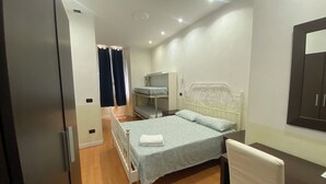 Une chambre à coucher avec un lit, une chaise, un bureau et une armoire.