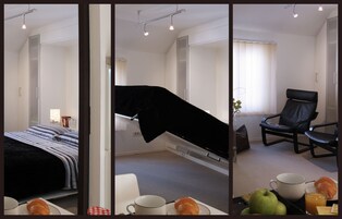 A hotel room with a bed, a chair, a dining table with breakfast items, and a window with curtains.