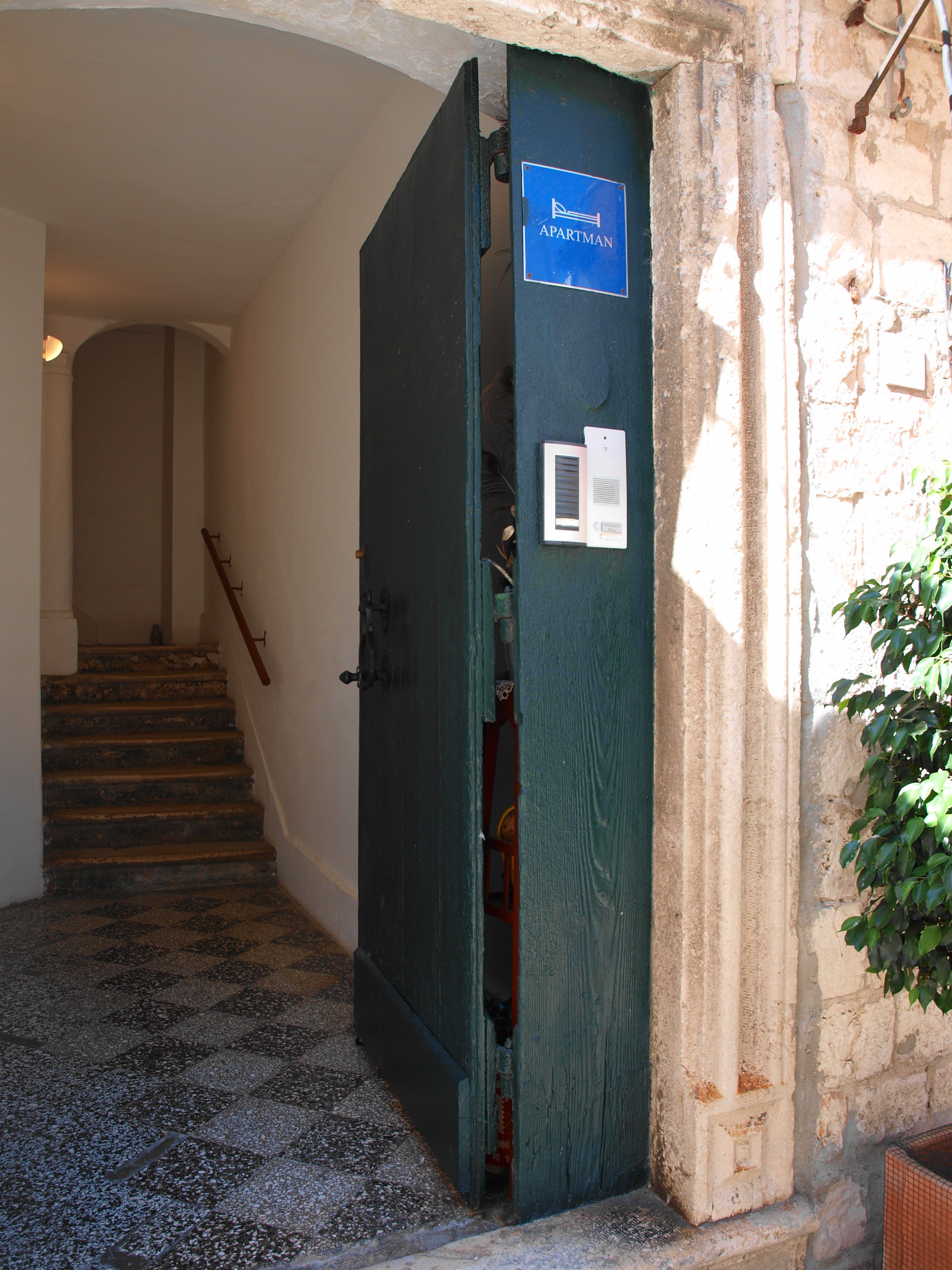 A staircase leading to an apartment with a sign indicating it is an apartment.