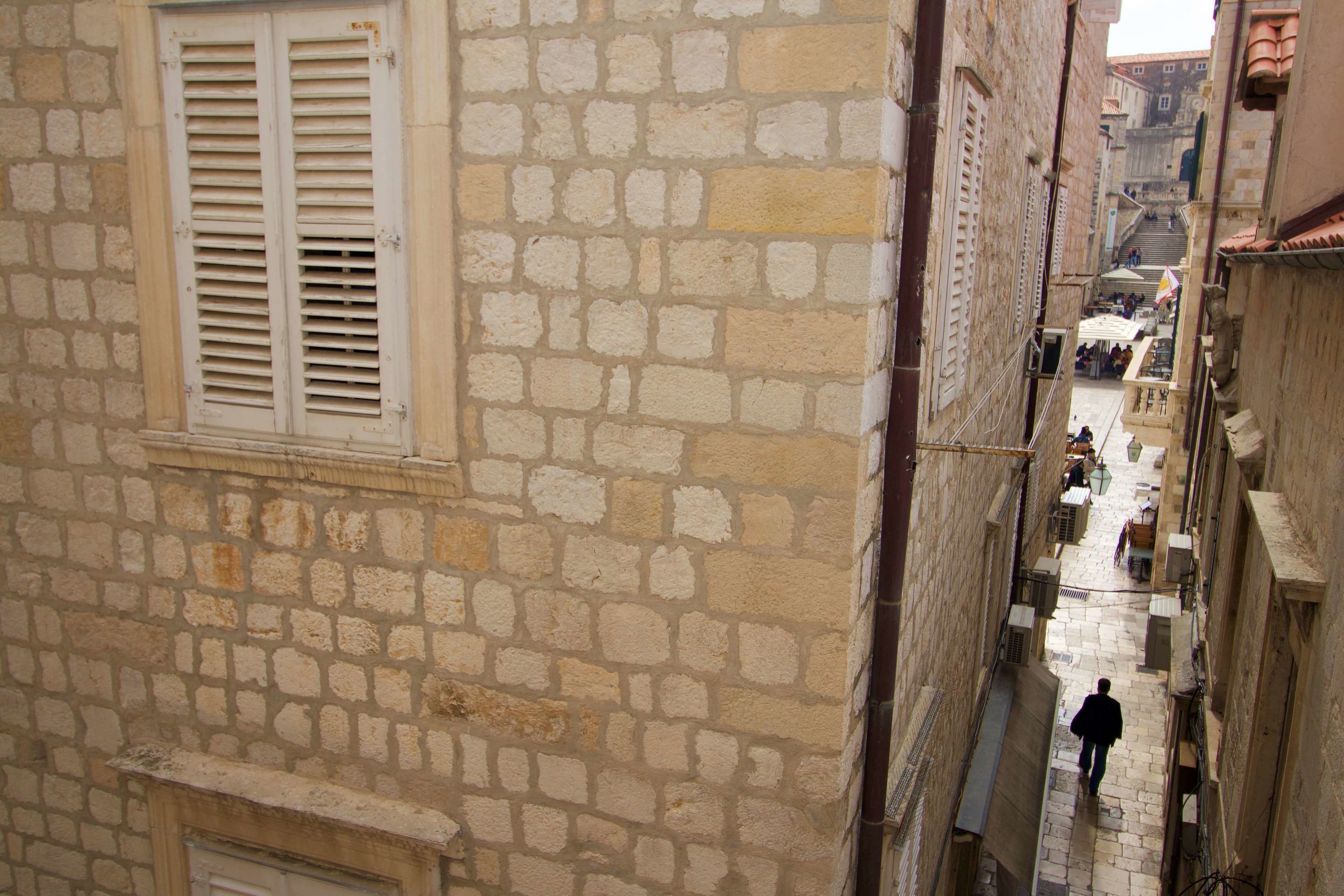 Un bâtiment étroit en pierre, doté d’une fenêtre et de volets.