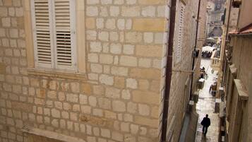 Un bâtiment étroit en pierre, doté d’une fenêtre et de volets.